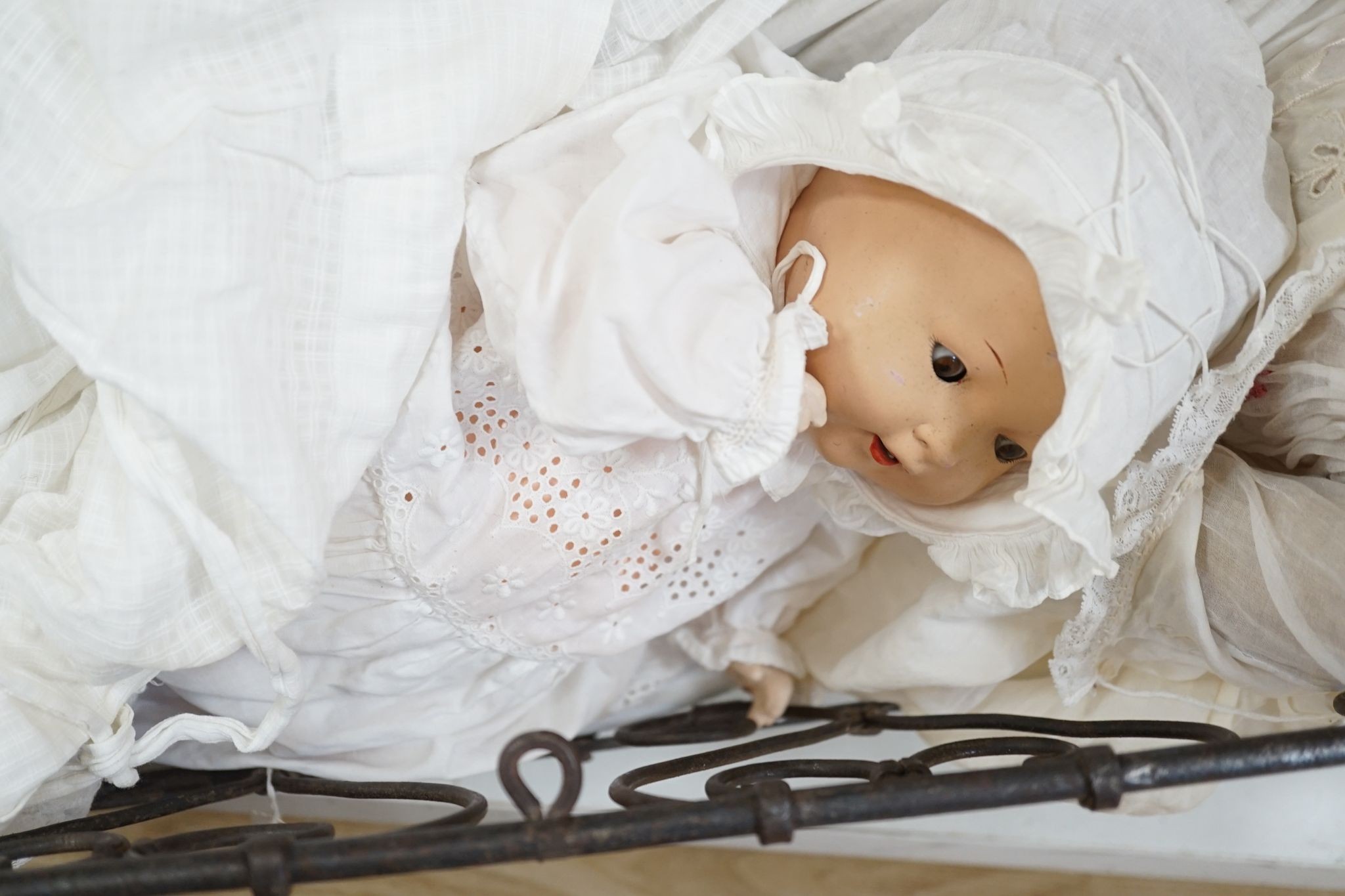 3 Armand Marseille bisque head dolls with sleeping eyes and 4 others in a wrought iron dolls crib 80cm